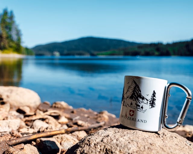 Coffee mug sitting next to the lake